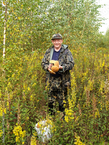 The happy man costs with mushrooms in hands (focus on mushrooms)