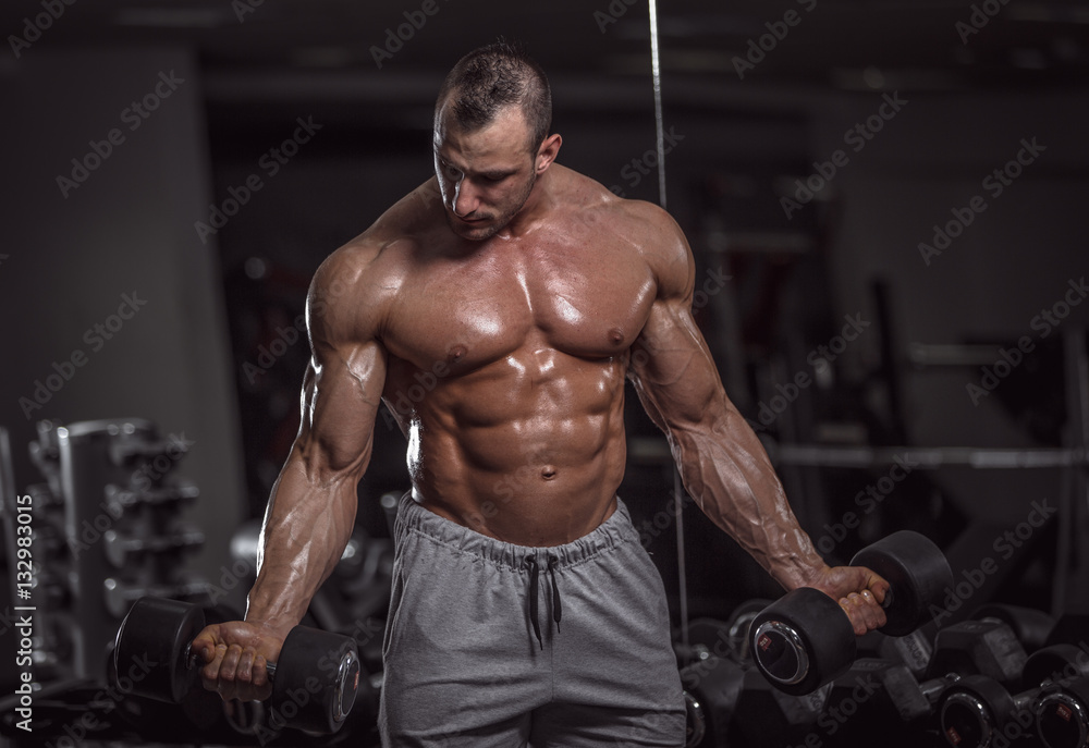 Handsome muscular man in gym.
