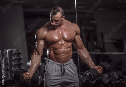 Handsome muscular man in gym.