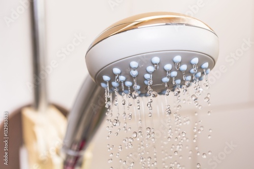 Close up of a shower head with sprinkling water