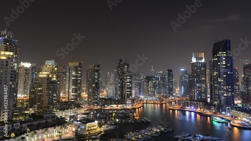 DUBAI, UNITED ARAB EMIRATES, October 22, 2014: Dubai Marina time lapse, night transition overlooking the area's skyscrapers and waterways. Dubai, United Arab Emirates.