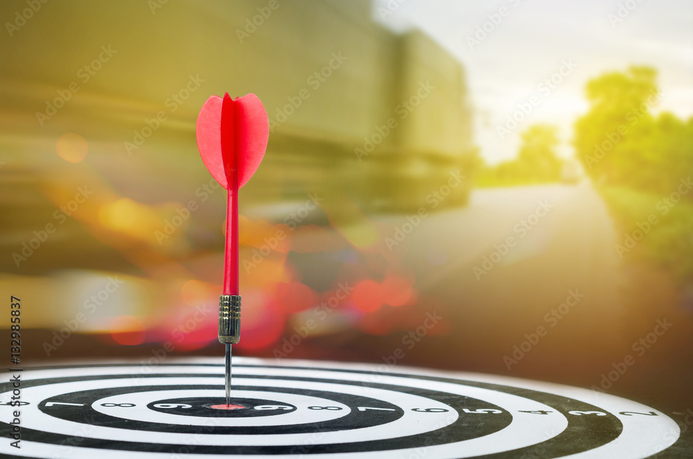 Close up shot red dart arrow on center of dartboard with transpo Close up shot red dart arrow on center of dartboard with transpo