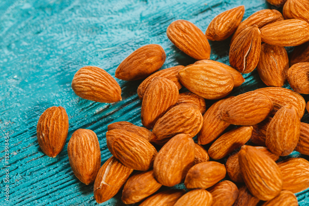 Fototapeta premium handful of almonds on a blue wooden background