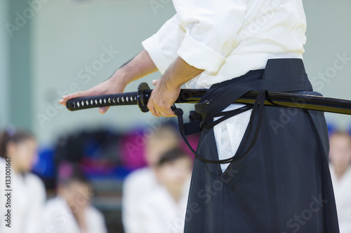 A male martial arts instructor with katana on seminar. Selective focus