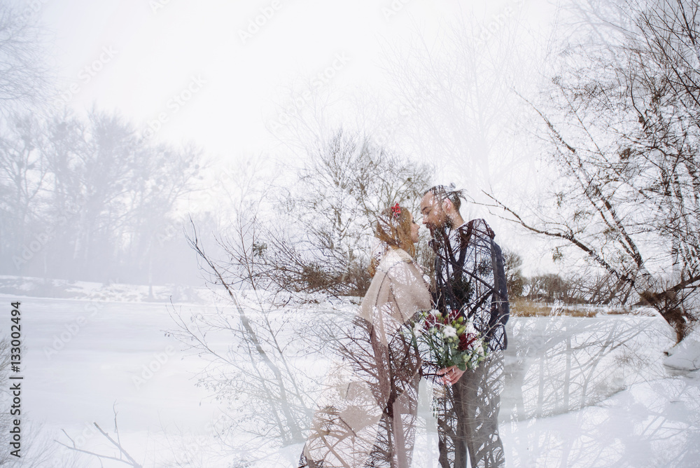 Stylish beautiful young couple bride and groom standing on the background of a winter landscape  river. Double exposhure