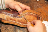 Repairing a brown leather shoe shows the craftsmanship of a Dutch shoemaker in Oegstgeest.