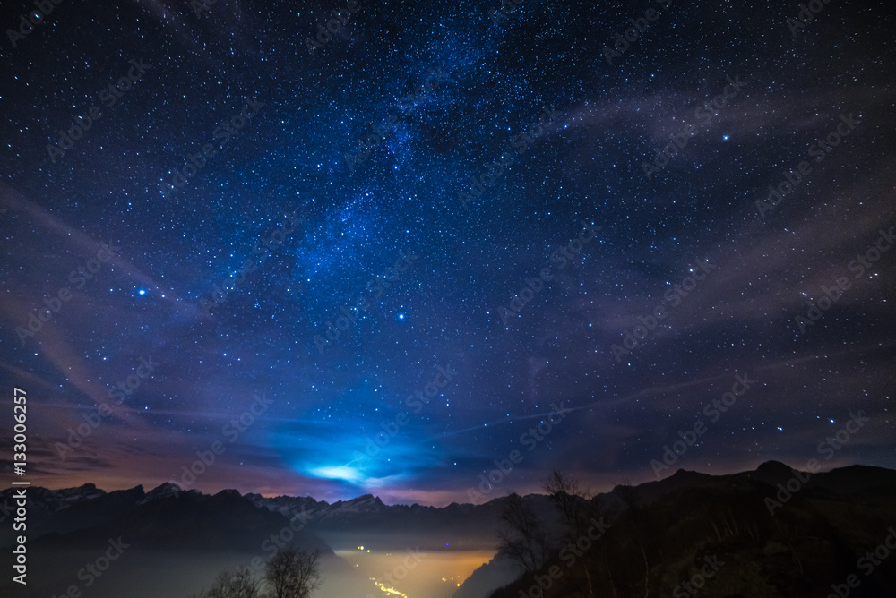 Naklejka premium Noc w Alpach pod rozgwieżdżonym niebem i światłem księżyca