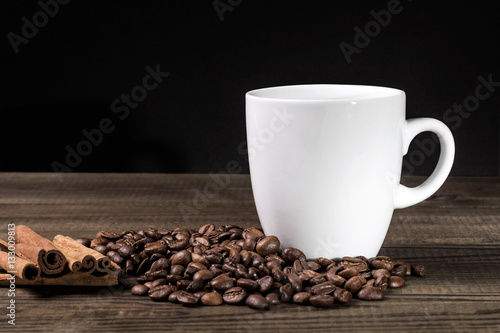 Coffe cup with coffee beans and cinnamon on wooden table. image with copy space