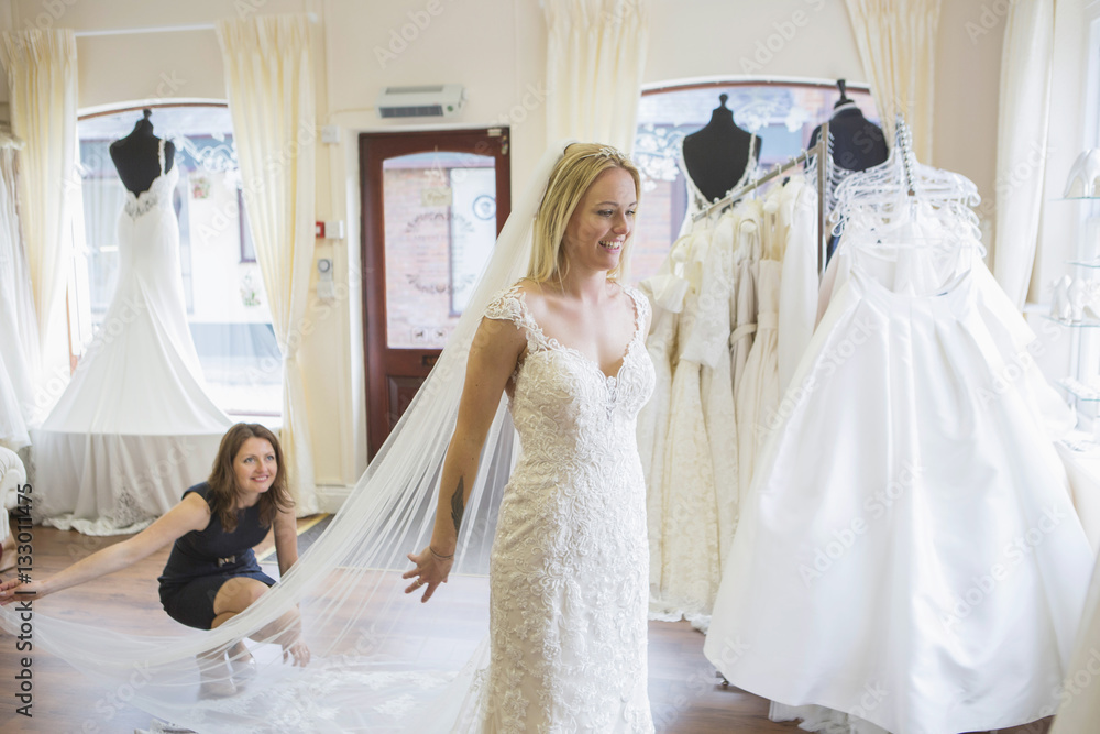 Female customer in bridal shop trying on wedding dress Female customer in bridal shop trying on wedding dress