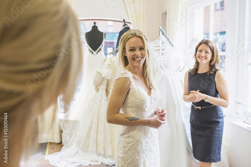 Female customer in bridal shop trying on wedding dress