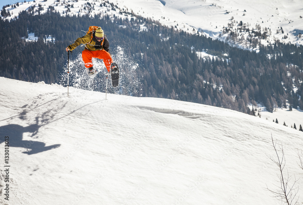 Men with snowshoes jumping in Alpine scenery Men with snowshoes jumping in Alpine scenery