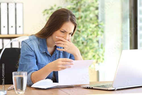 Foto Worried entrepreneur girl reading a letter