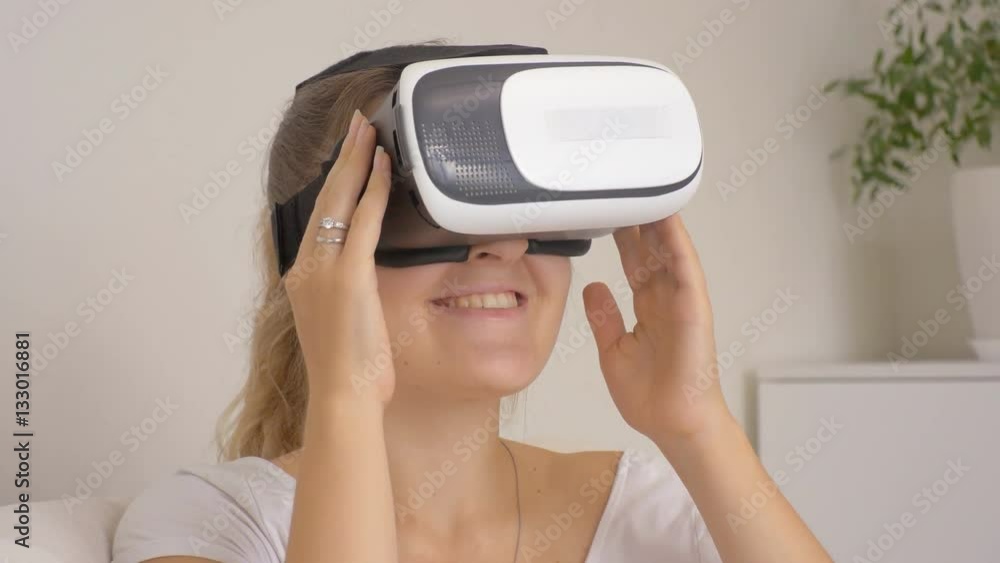 Portrait of smiling young woman using virtual reality headset at home. Footage shot at 4k Portrait of smiling young woman using virtual reality headset at home. Footage shot at 4k