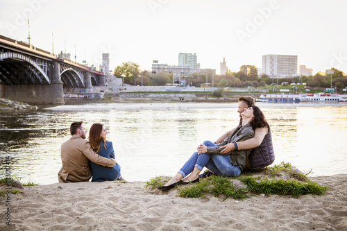 Group of tourists taking a break on water's edge in city