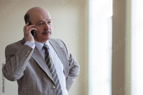 Man in suit talking on the phone, solving important questions.