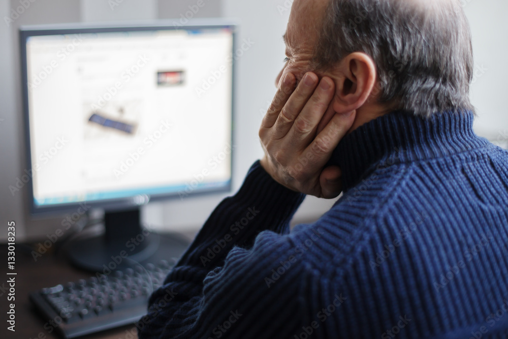 Man looking for information on the Internet. Retired develops computer technology at home Man looking for information on the Internet. Retired develops computer technology at home