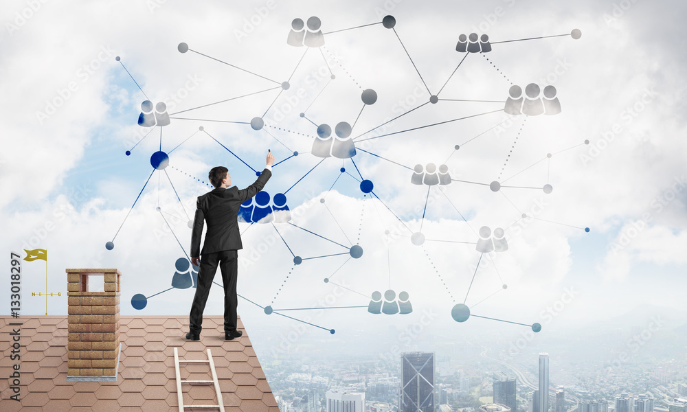 Businessman on house roof presenting networking and connection concept. Mixed media Businessman on house roof presenting networking and connection concept. Mixed media