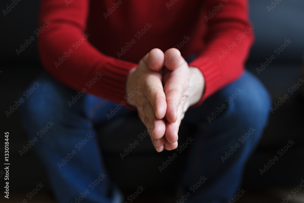Caucasian man clasped his hands together, praying or asking Caucasian man clasped his hands together, praying or asking