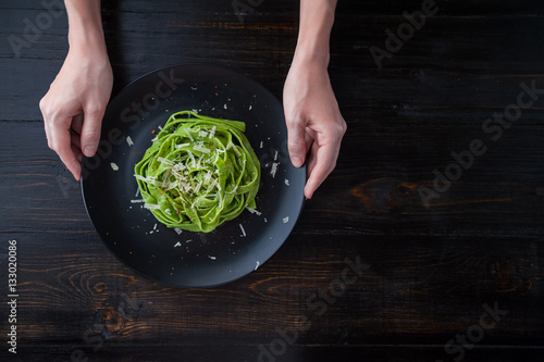 delicacy green pasta with homemade spinach and broccoli under a parmesan cheese and sesame seeds photo