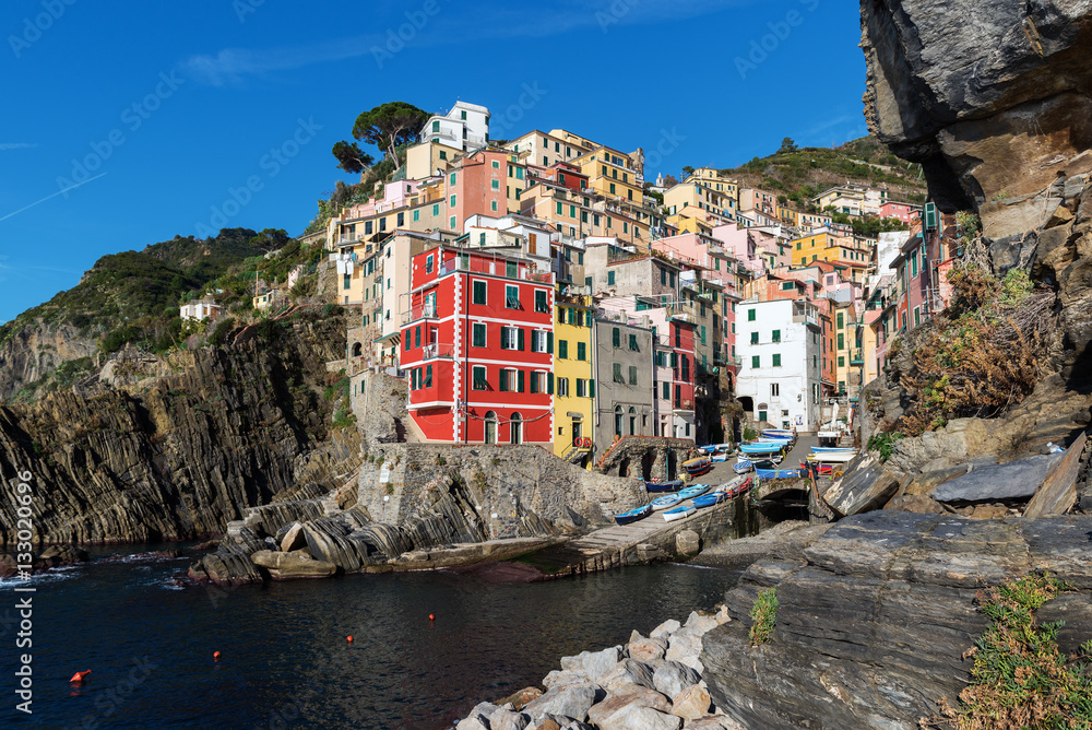 Houses on rocks near sea bay of Riomaggiore town in Cinque Terre national park in Italy