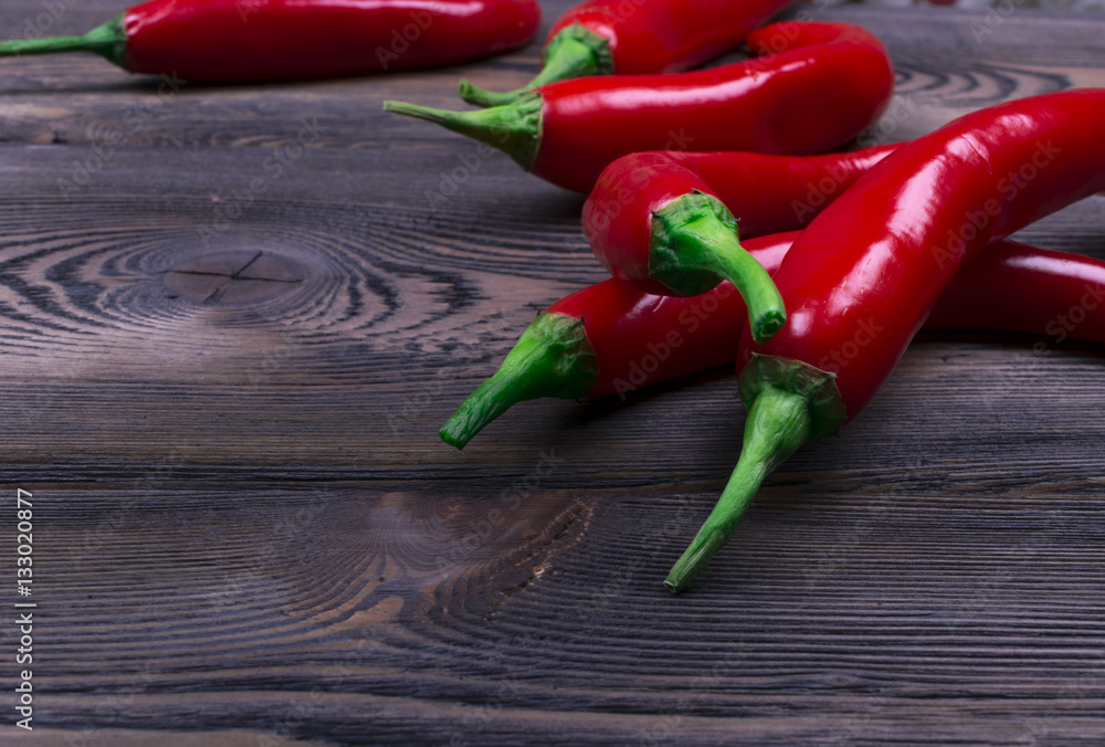 Red chili pepper on the dark wood background