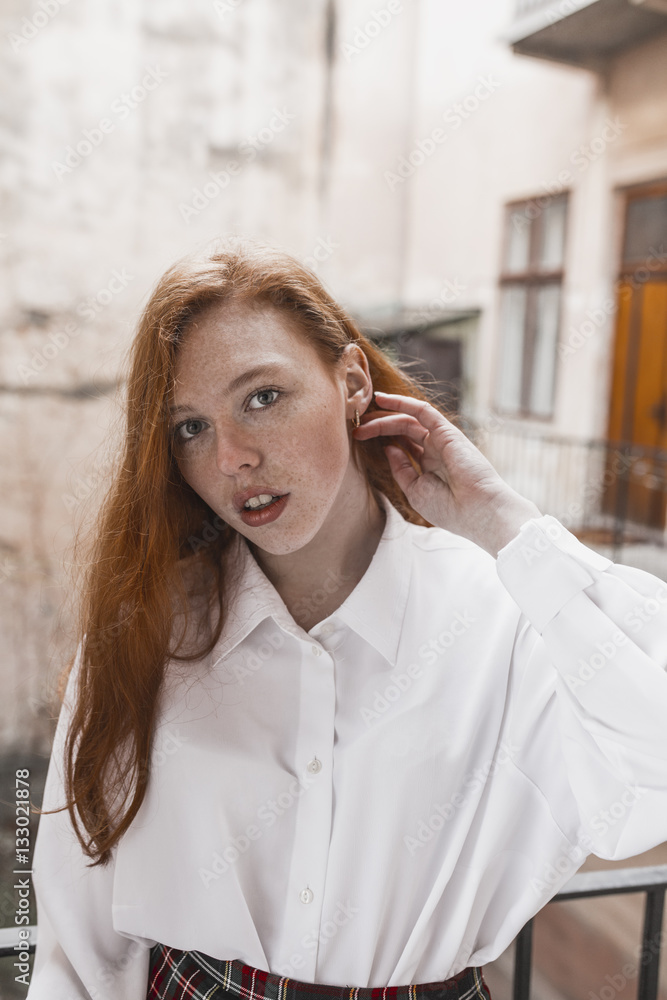 Pretty redhead model with freckles in a white shirt Pretty redhead model with freckles in a white shirt