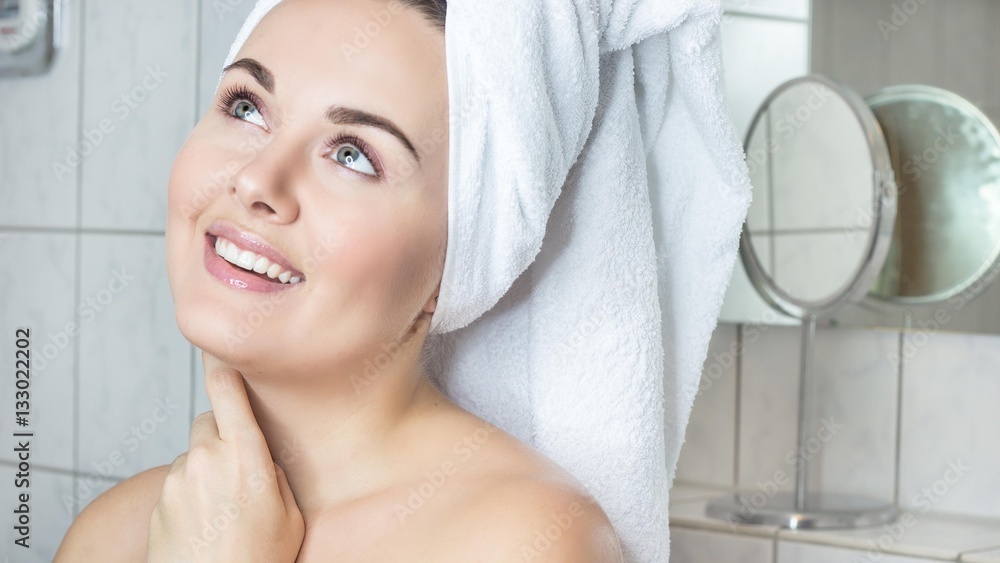 Happy young woman with a white towel on her head. The girl after a shower in a towel. Happy young woman with a white towel on her head. The girl after a shower in a towel.