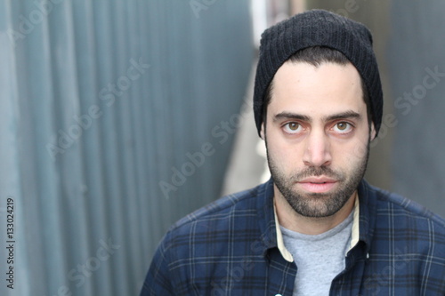 Portrait of young man against empty urban alley way - Stock image