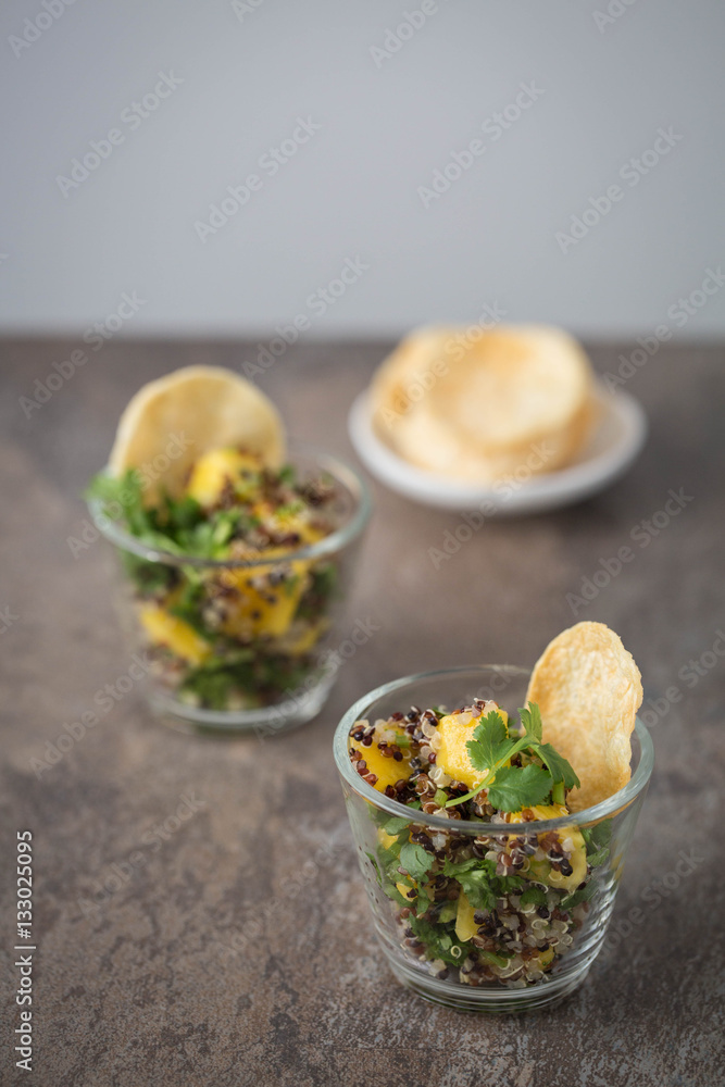 Quinoa and mango salad in a glass, natural brown stone background. Quinoa and mango salad in a glass, natural brown stone background.