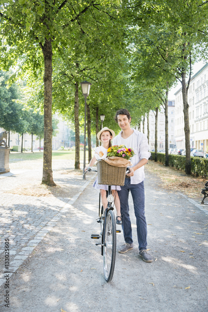 Father and daughter with bicycle and flowers Father and daughter with bicycle and flowers
