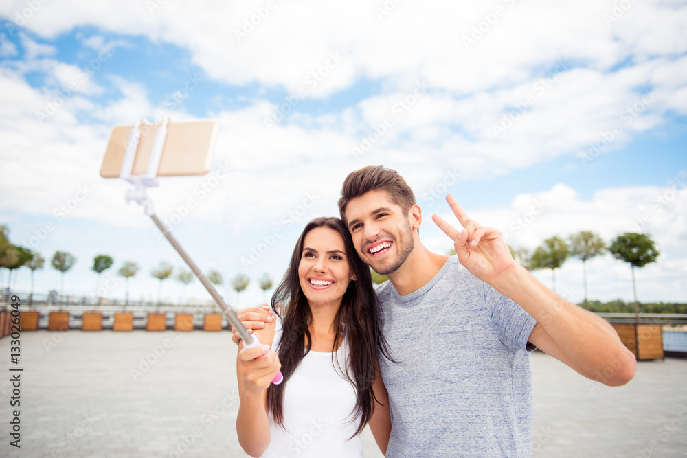 Smiling attractive man and woman making selfie on monopod Smiling attractive man and woman making selfie on monopod