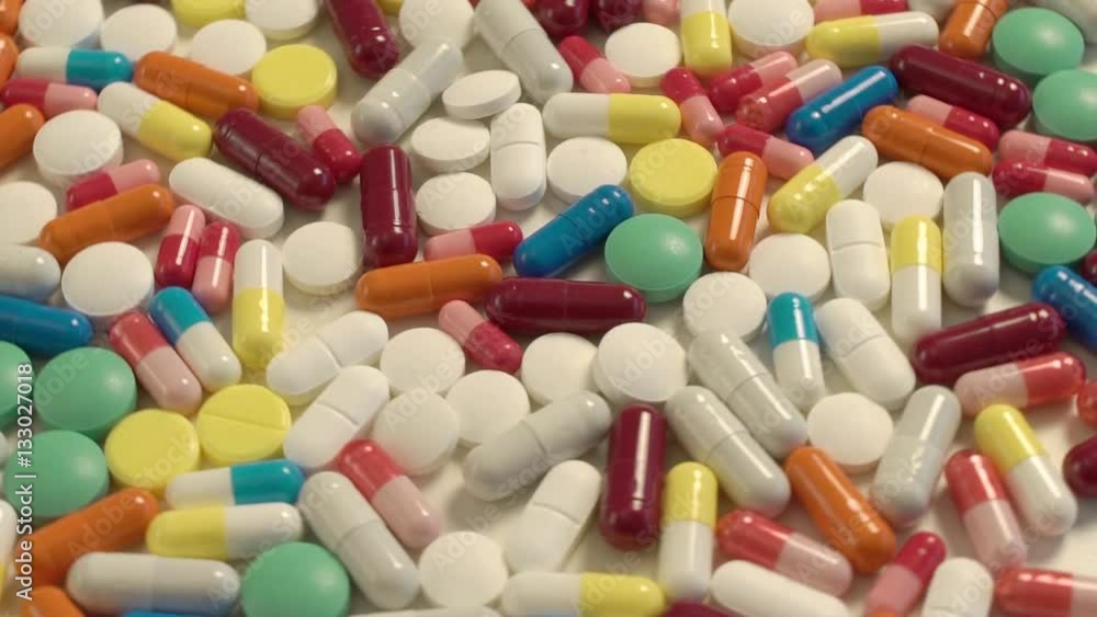 a lot of colored capsules and tablets swirling in a circle a lot of colored capsules and tablets swirling in a circle