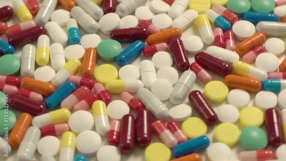 a lot of colored capsules and tablets swirling in a circle a lot of colored capsules and tablets swirling in a circle