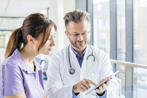 Doctor and nurse looking at digital tablet in hospital