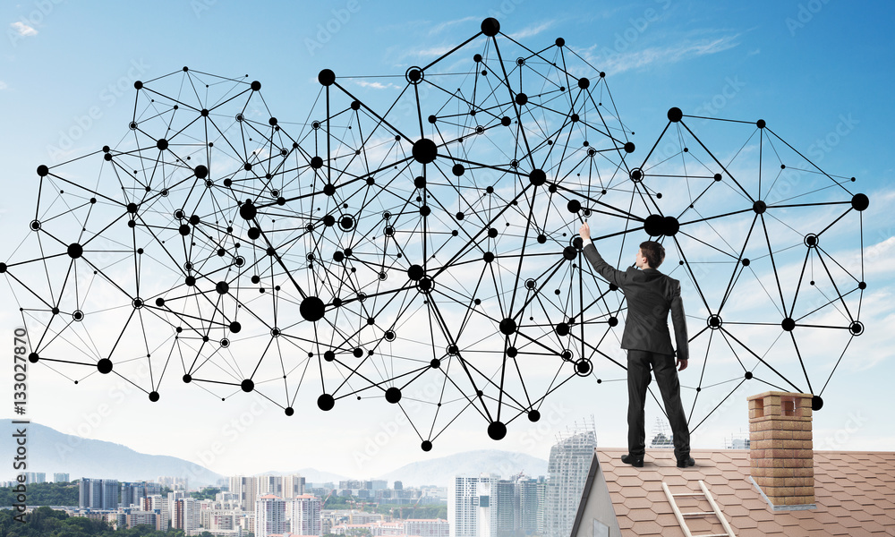 Businessman on house roof presenting networking and connection concept. Mixed media Businessman on house roof presenting networking and connection concept. Mixed media