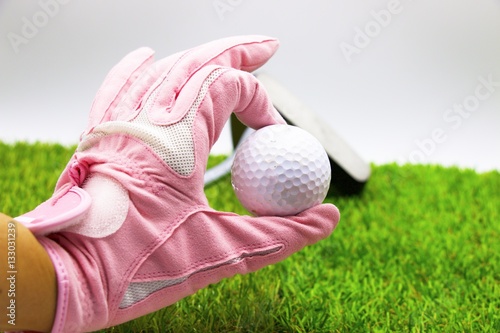 lady golfer is holding golf ball with pink glove on white background,