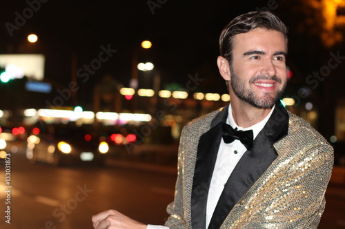 Smiling man in sparkly golden tuxedo smiling. - Stock image with Copy Space  photo