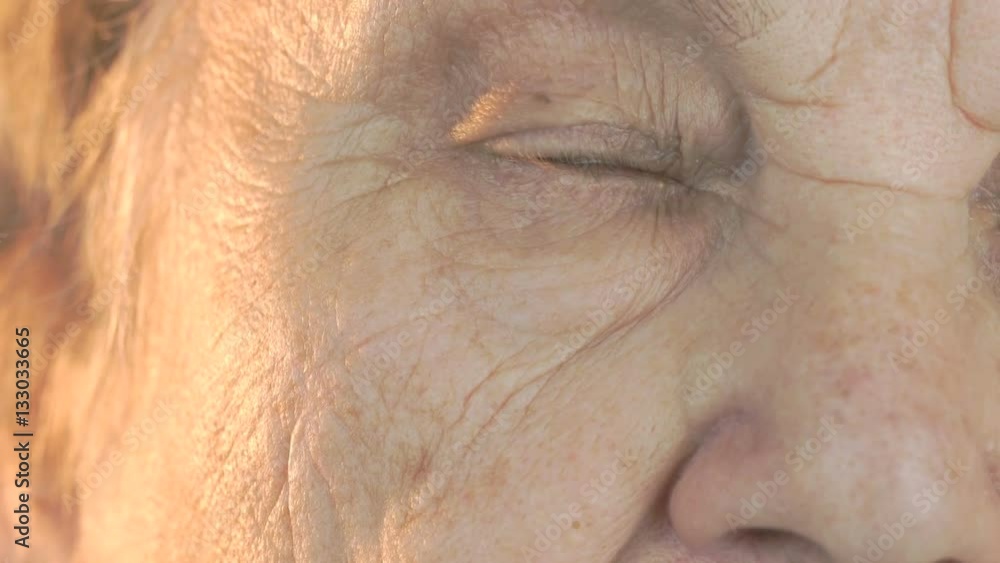 Elderly woman opening and closing eyes. Close up Elderly woman opening and closing eyes. Close up