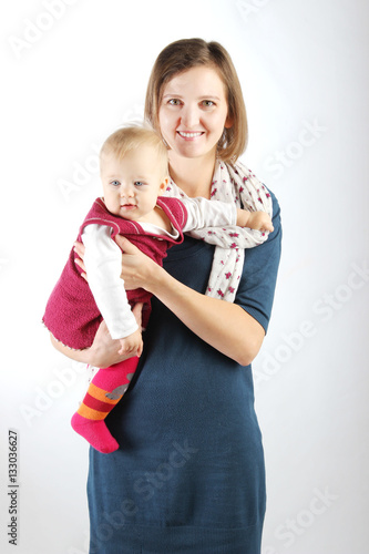 Family, children, people concept. Studio shot of a beautiful mother carrying her adorable baby girl.
