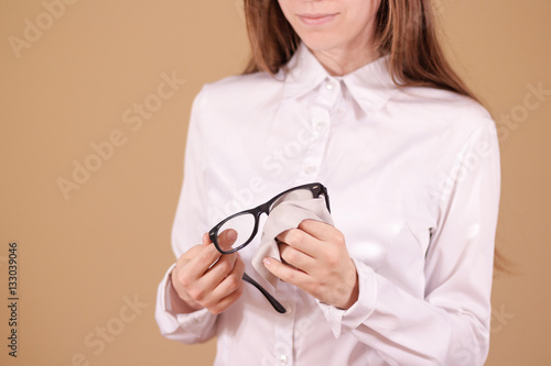Women hand cleaning glasses lens with isolated background