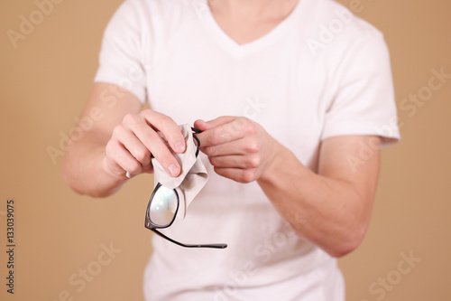 Man hand cleaning glasses lens with isolated background