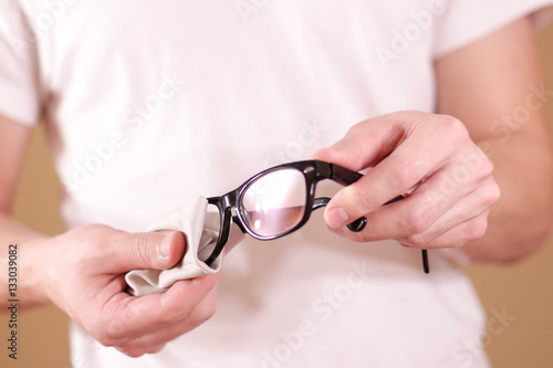 Man hand cleaning glasses lens with isolated background