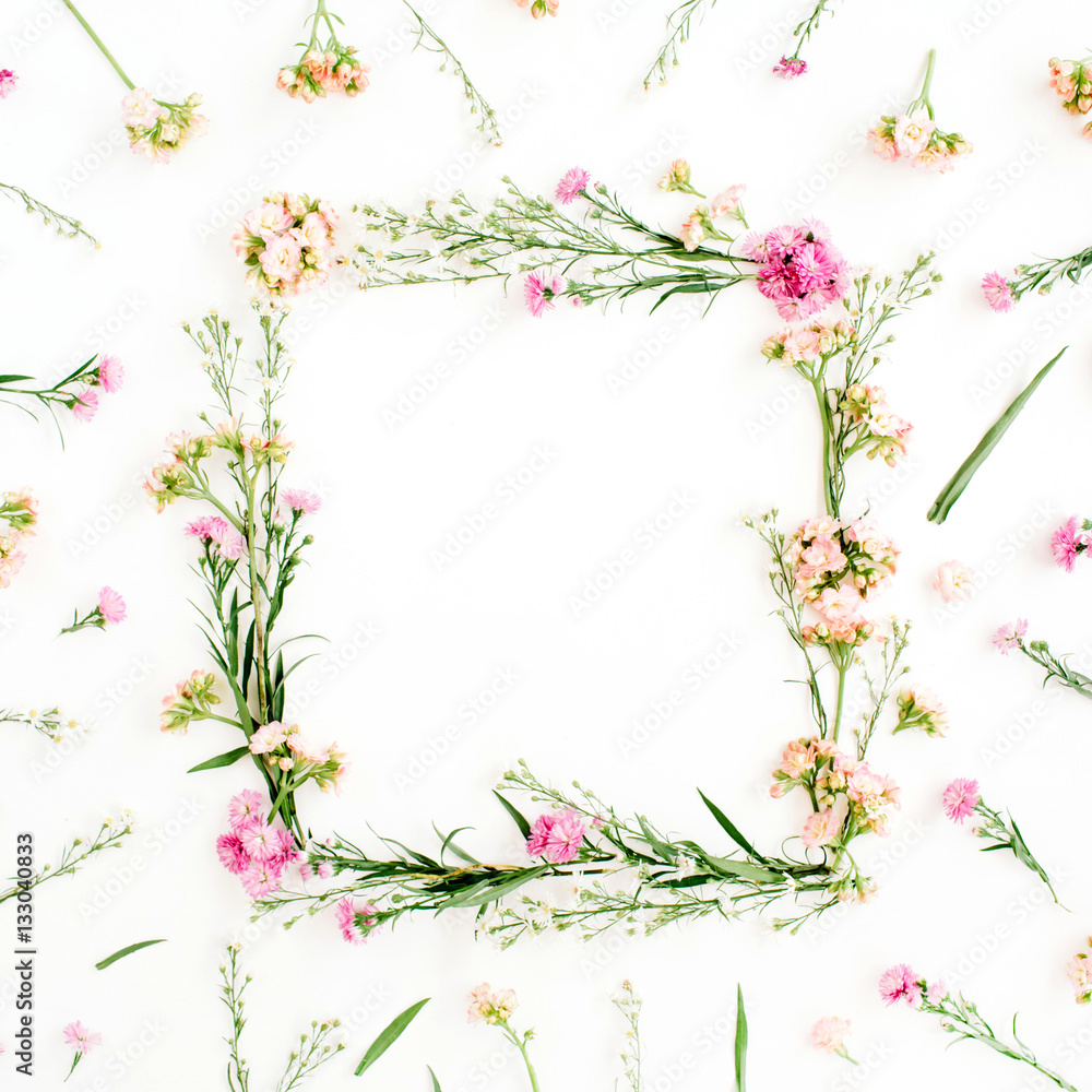 Wreath frame made of pink and beige wildflowers, green leaves, branches on white background. Flat lay, top view. Valentine's background Wreath frame made of pink and beige wildflowers, green leaves, branches on white background. Flat lay, top view. Valentine's background