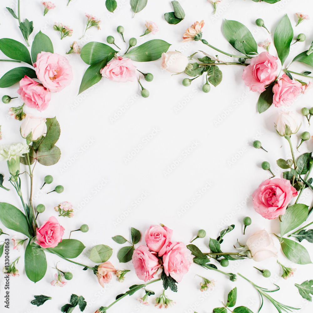 Round frame made of pink and beige roses, green leaves, branches, floral pattern on white background. Flat lay, top view. Valentine's background