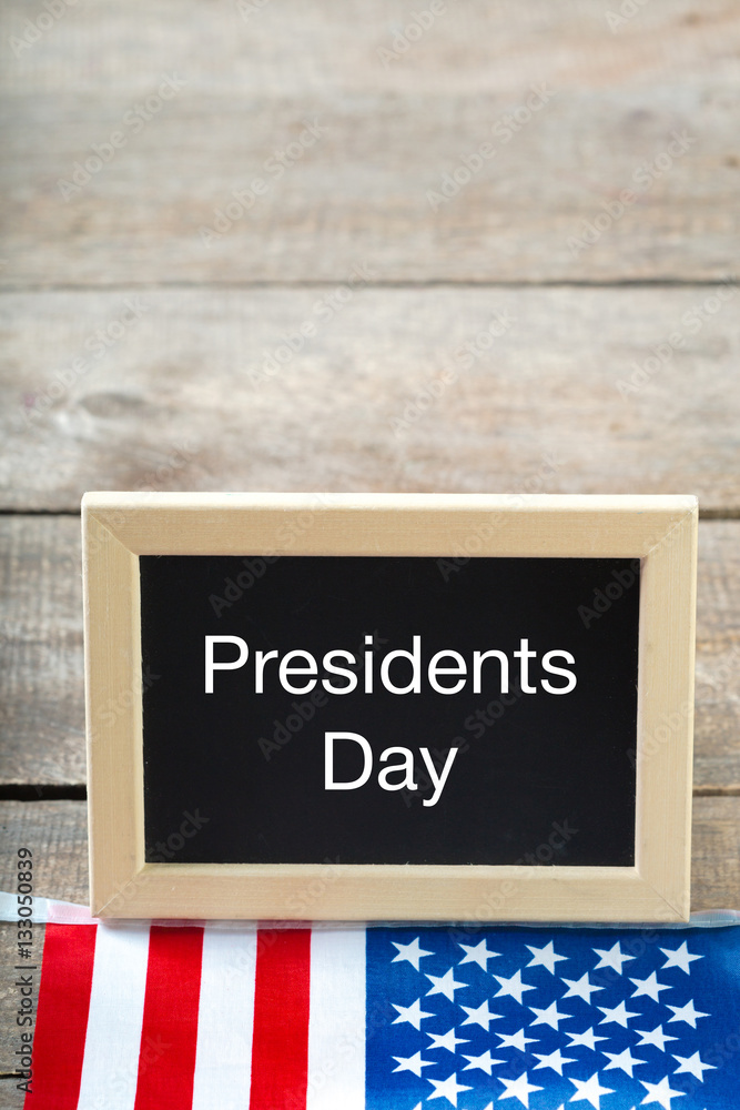 the text happy presidents day written in a chalkboard and a flag of the United States the text happy presidents day written in a chalkboard and a flag of the United States