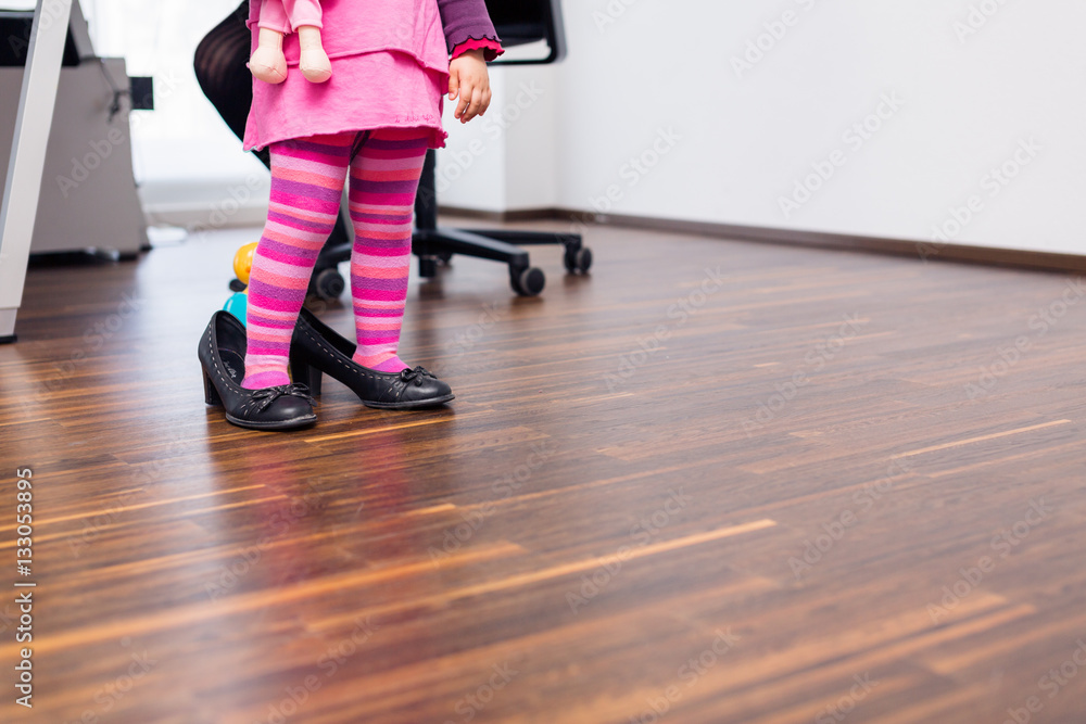 Little Girl Wearing Large Shoes In Office