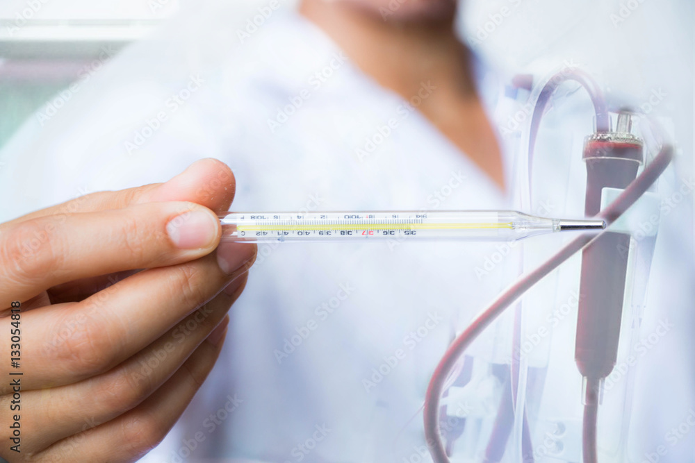 Doctor hold thermometer on tube blood background Doctor hold thermometer on tube blood background