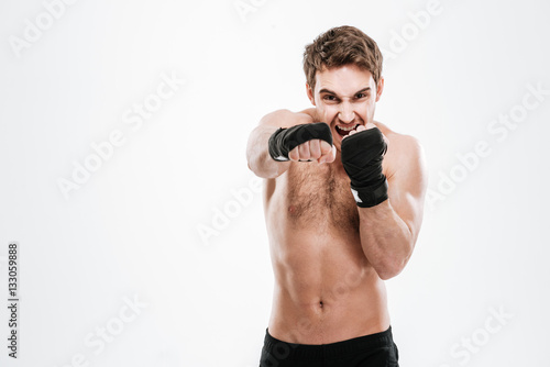 Agressive young man boxer make boxing exercises