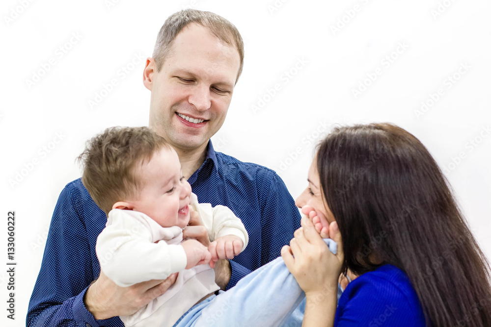 Smiling young parents and their child are very happy, they are at home. happy family mother, father and son on white background Smiling young parents and their child are very happy, they are at home. happy family mother, father and son on white background
