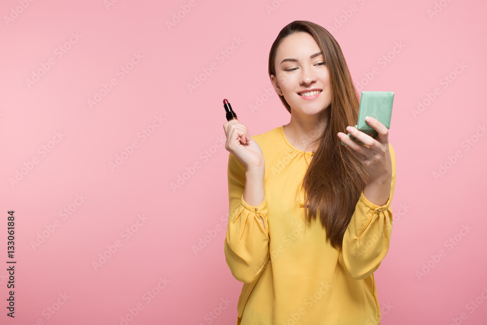 girl using lipstick and looking in the pocket mirror girl using lipstick and looking in the pocket mirror